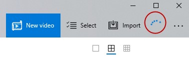 What does the blue rotating circle mean at the top right of the Windows Photos app 3e38a0e3-8e62-427d-b34e-d6ebc1a18801?upload=true.jpg